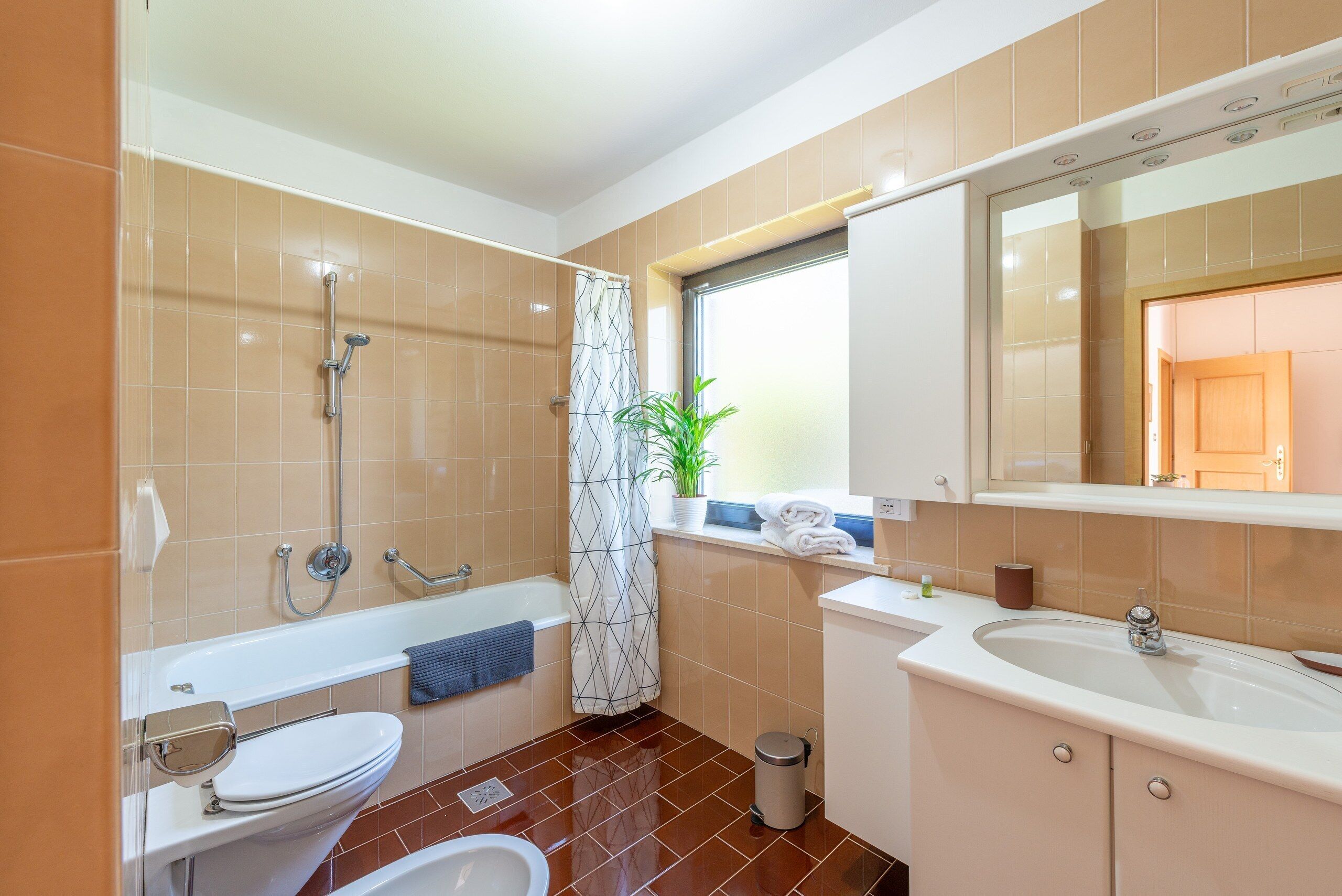 Une salle de bain équipée d’une baignoire, de toilettes, d’un lavabo et d’une douche.