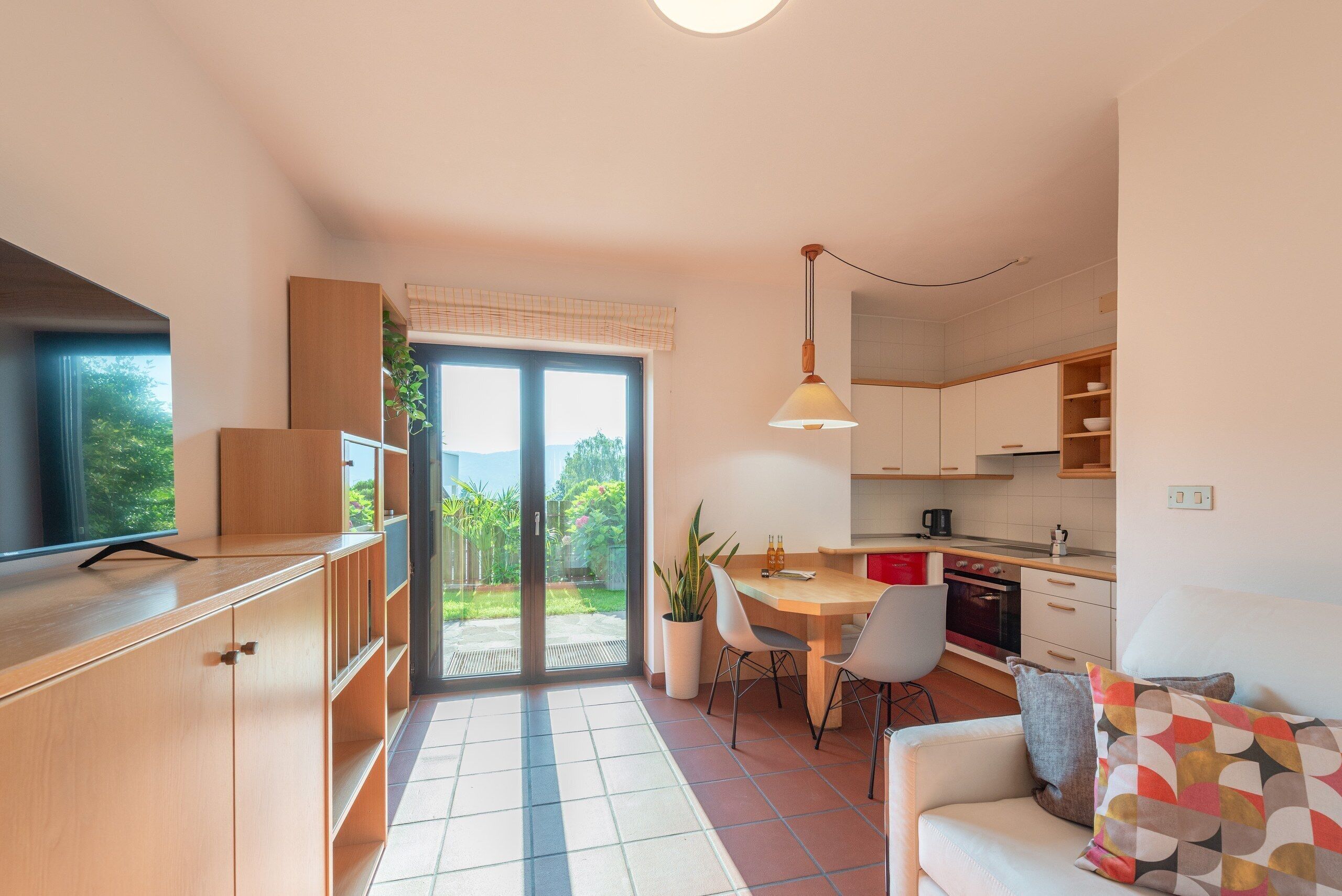 Une cuisine moderne avec un coin repas, un canapé et une vue sur l’extérieur.