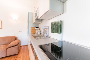 Eine kleine Küche mit Einbauherd, Spüle und Holzschrank.