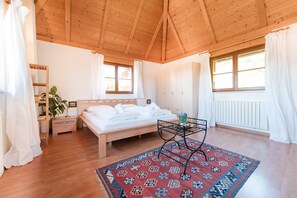 A bedroom with a wooden ceiling, a bed, a bedside table, a nightstand, a window with curtains, and a patterned rug. - 718B Apartment  Ansitz Wieshof (Caldaro sulla strada del vino)