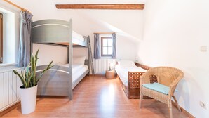 A room with a bunk bed, a wicker chair, a potted plant, and a window with curtains. - 718B Apartment  Ansitz Wieshof (Caldaro sulla strada del vino)