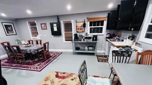 A compact living space with a dining area, kitchen, and a small seating area. - HB Rustic Retreat - WGI - Book now for Race Weekend. A fun place for all ages. (Beaver Dams)