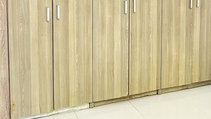 A large wooden wardrobe with multiple compartments and handles.