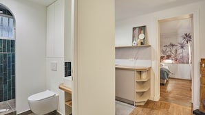A modern bathroom with a toilet, vanity, and shower area. - Modern Apartment - Eiffel Tower Trocadero Place (Paris)