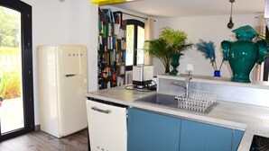 A compact kitchen with a white refrigerator, a sink, and a coffee maker. - Quiet house near Montpellier in a village on the edge of a forest (Teyran)