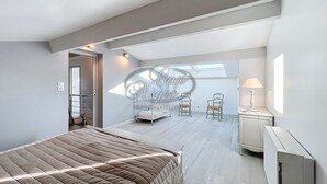 Un dormitorio con cama, escritorio, silla y ventana que deja entrar luz natural.