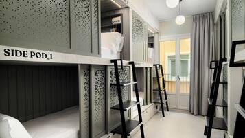 Una habitación de hotel moderna con literas, una escalera y un escritorio pequeño.