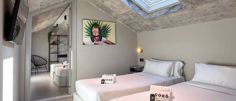 A modern bedroom with two beds, a skylight, a painting, and a TV on the wall.