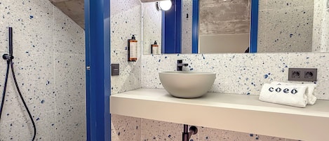 A bathroom with a white sink, blue accents, a mirror, and a towel with text.