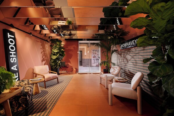 Een moderne lounge met zitplaatsen, planten en een bordje met de tekst 'SHOWHAVEN'.