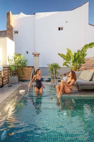 Una piscina al aire libre, sombrillas. Coeo Hostel Hernan Ruiz