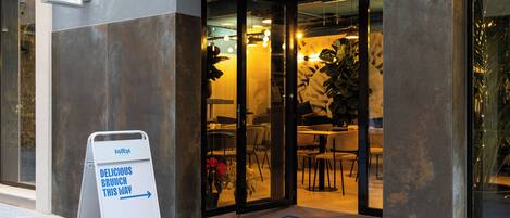 A restaurant entrance with a sign reading "BAROLA BRUNCH & BISTRO" and a directional sign for "DELICIOUS BRUNCH THIS WAY".