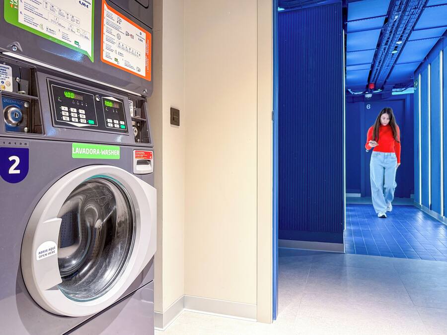 A public laundromat with a washing machine, a control panel, and a sign indicating a 4.00 euro fee.