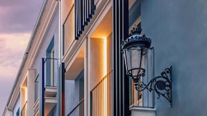 Una hilera de edificios modernos con balcones, una farola y locales comerciales.