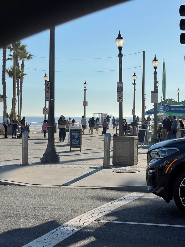 Un paseo marítimo con farolas, palmeras y un cartel que anuncia un restaurante.