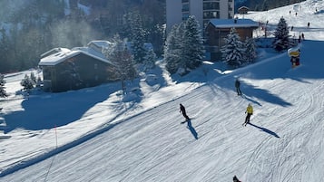 Une station de ski avec un grand bâtiment, probablement un chalet, et une piste de ski.