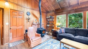 A cozy room with a fireplace, leather chair, sofa, and bookshelves.