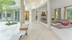 Amplia sala de estar con diseño moderno, que cuenta con un gran ventanal, un conjunto de sofás y una mesa de centro.