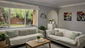 Un soggiorno con due divani, un tavolino da caffè e vista su un giardino.