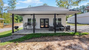 A covered patio area with outdoor seating, a grill, and a view of the surrounding landscape. - 4-bedroom Chalet Overlooking Pickwick Landing Golf Course (Counce)