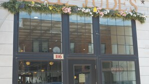 Een gebouw met een groot bord met de tekst 'CAFE JUDES' boven de ingang.