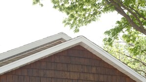 Een huis met een blauwe deur, het getal '366' boven de deur, een veranda met blauwe stoelen en een stenen trap naar de deur.