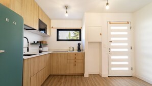 A modern kitchen with wooden cabinets, a built-in oven, and a window above the sink.