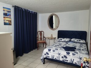 A bedroom with a bed, a chair, a small table, and a mirror. - Centrally located 2-bedroom & 1-bathroom in Little Havana, Miami w/AC WiFi C1&2 (Miami)