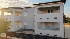 A modern two-story building with balconies, a flat roof, and a visible staircase. - 1 bedroom beautiful apartment in Vir (Vir)