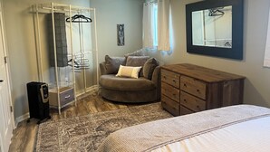A bedroom with a wardrobe, a chest of drawers, a bed, and a rug. - Charming 3-bedroom detached cottage on horse farm near Lexington and Georgetown. (Paris)