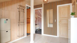 A hallway with wooden walls, a white door, and a refrigerator on the left. - 3 bedroom amazing home in Toftlund (Toftlund)