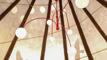 Un plafond avec des poutres en bois et des lampes sphériques suspendues.