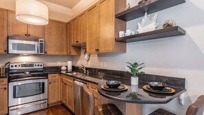 Una cocina moderna con armarios de madera, electrodomésticos de acero inoxidable y una isla central con asientos.