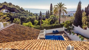 A rooftop pool with terracotta tiles, surrounded by lush greenery and a view of the sea. - Gorgeous home in Mijas (Mijas)