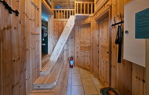 Ein schmaler Holzkorridor mit einer Holztreppe, die zu einem Erker führt.