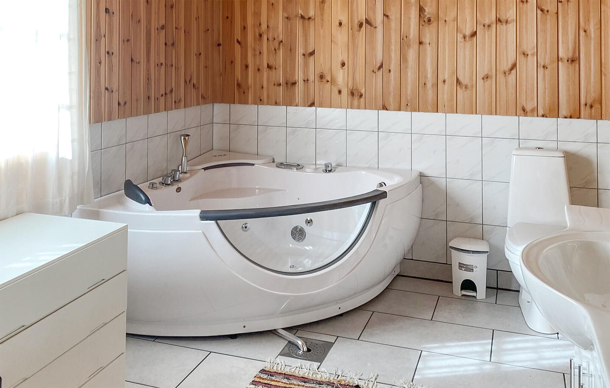 A modern bathroom with a freestanding bathtub, a toilet, and a sink.