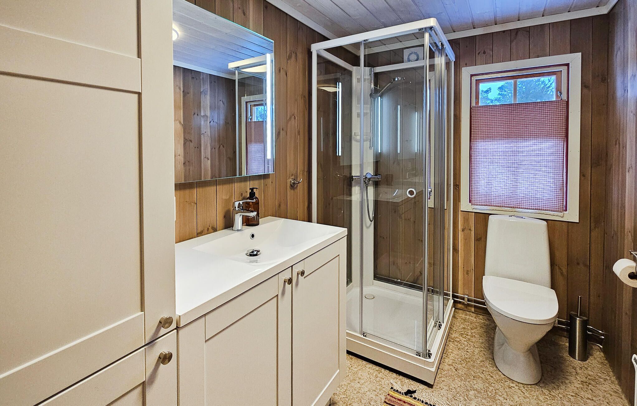 Une salle de bain avec une douche, des toilettes et un lavabo avec un miroir au-dessus.