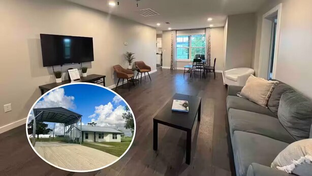 A modern living room with a flat-screen TV, a ceiling fan, and a dining area with a table and chairs.