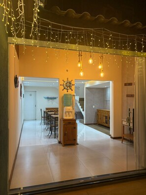 A modern interior with a dining area, a staircase, and a kitchen. - Suítes Brisa do Mar (Búzios)
