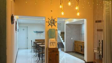 A modern interior with a dining area, a staircase, and a kitchen.