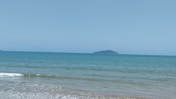 A beach with a clear sky and calm sea.