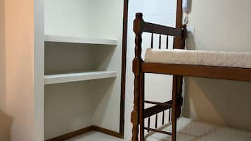 Ein Stockbett in einem Raum mit weißen Wänden und Fliesenboden.