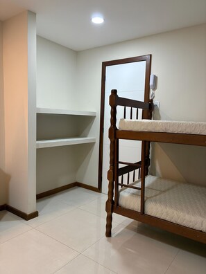 A bunk bed in a room with white walls and a tiled floor. - Suítes Brisa do Mar (Búzios)