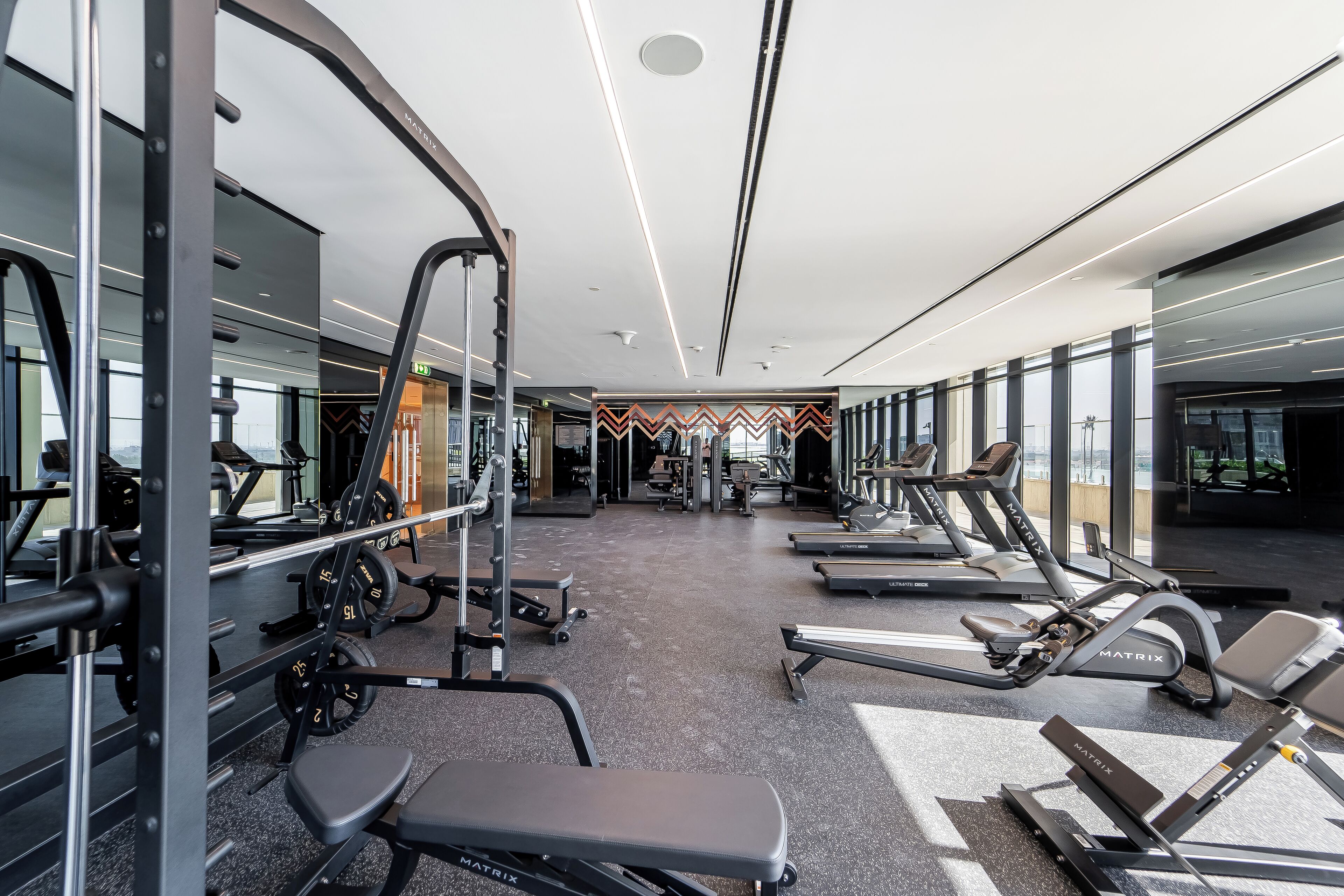 A gym with various exercise equipment, including treadmills and weight machines.