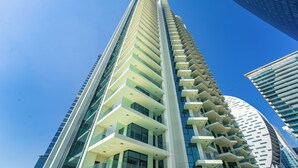 A high-rise building with multiple balconies and large windows.