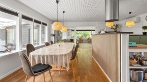 A modern dining area with a long table, chairs, and pendant lights. - 3 bedroom beautiful home in Gilleleje (Gilleleje)