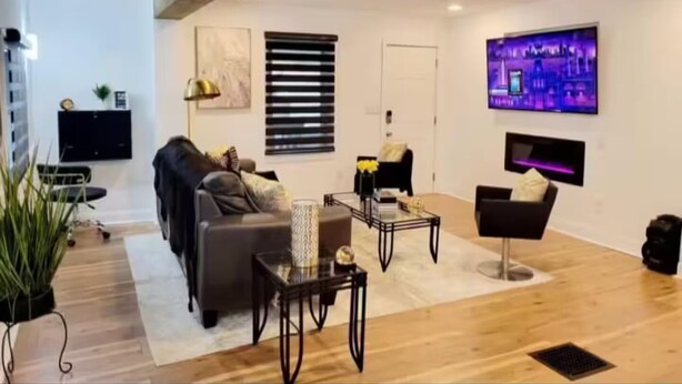 Ein modernes Wohnzimmer mit Sofa, Couchtisch und Fernseher.