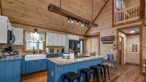 A spacious kitchen with a large island, blue cabinetry, and a wooden ceiling. - Large Family Getaway Cabin w/Hot Tub + Game Room - Minutes to Blue Ridge (Blue Ridge)