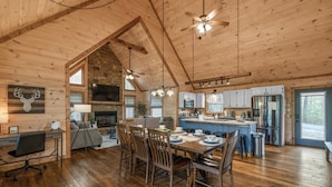 A spacious wooden cabin with a dining area, kitchen, and living room. - Large Family Getaway Cabin w/Hot Tub + Game Room - Minutes to Blue Ridge (Blue Ridge)