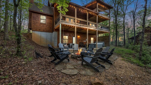 A two-story wooden cabin with a deck, outdoor seating area, and a fire pit. - Large Family Getaway Cabin w/Hot Tub + Game Room - Minutes to Blue Ridge (Blue Ridge)